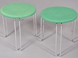 pair of green stools with metal legs on a white surface