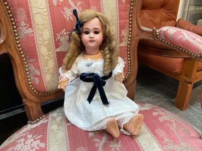 a doll that is sitting on a chair in a room