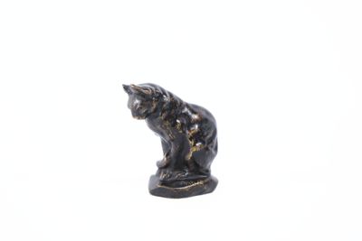 a small statue of a cat on a white surface