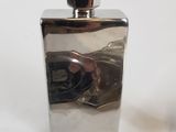 a silver flaskt with a black handle next to a lighter