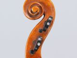 an antique violin with a scroll and a bow on a stand