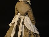 an image of a doll in a dress and bonnet on a black background