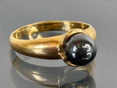an image of a gold ring with a black stone on it