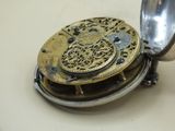 a small silver pocket watch sitting on top of a table