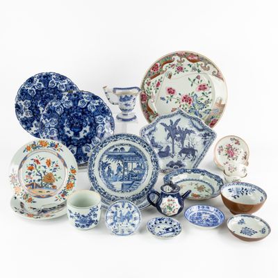 an assortment of blue and white plates and bowls on a white surface