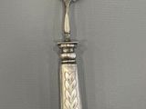 a silver spoon with a flower on it on a table