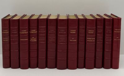 six livres rouges sont alignés sur une surface blanche