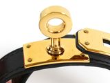 a close up of a hand holding a black and gold purse