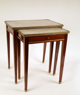 deux tables avec des plateaux en marbre et des pieds en laiton sur fond blanc