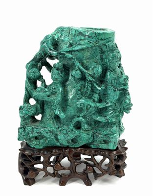 sculpture of a group of people on a rock with a tree in the background