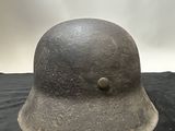 helmet on a black surface with a cloudy sky in the background
