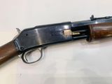 a close up of a gun with a wooden handle on a table