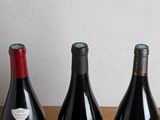 three bottles of wine sitting on a table next to each other