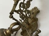 a brass bell hanging from the wall next to a chain