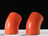 three orange plastic objects sitting on top of a white surface