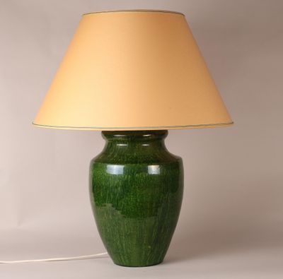 a large green vase with a beige shade on it