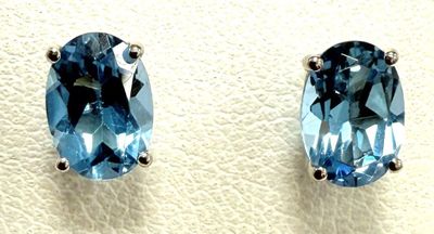 two pairs of blue topaze earrings on a white surface