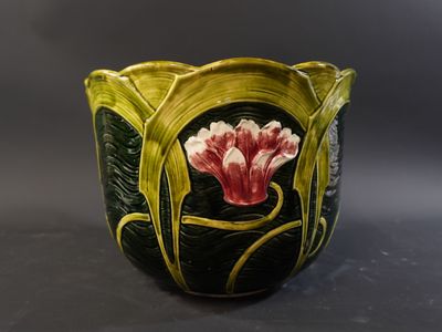 a close up of a vase with a flower painted on it