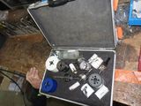 un homme tenant un outil dans un coffret posé sur une table
