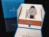 a box with a watch inside of it on a black surface