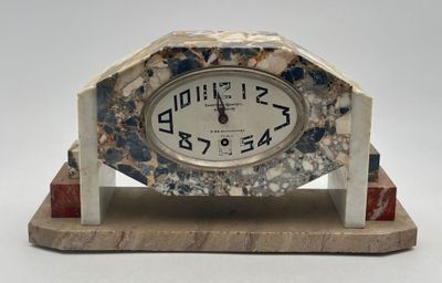 marble clock sitting on top of a wooden stand with a white background