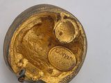 a gold plate with a bird on it on a white surface