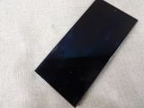a close up of a cell phone laying on a white surface
