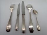 four forks, a knife, and a spoon on a table