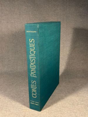 a green book sitting on top of a table next to a gray wall