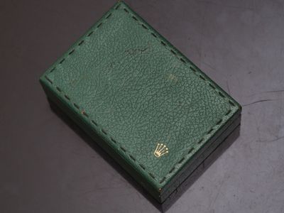 green leather box with a gold crown on the top of it