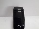 a small black cell phone sitting on a white surface