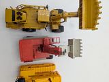 four toy trucks and a bulldozer on a white surface