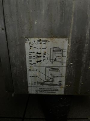 une affiche apposée sur le mur d'un immeuble indiquant qu'il est dangereux d'utiliser les toilettes