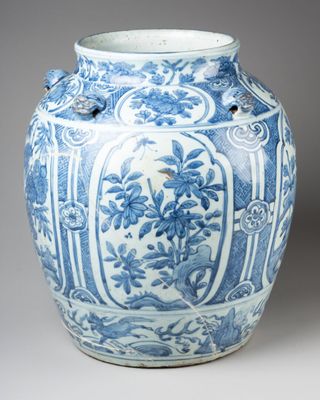 an old blue and white vase with a bird on top of it