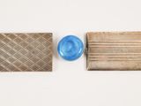 three different types of silver and blue glass items on a white surface