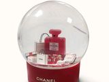 a snow globe with a chanel perfume bottle inside of it