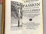 someone is holding an open book with a picture of a crucifix on it