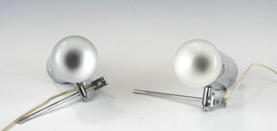une paire de lampes argentées posées sur une surface blanche, avec des fils