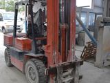 a red forklift truck parked in a garage