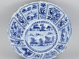 a blue and white plate with a landscape scene on it