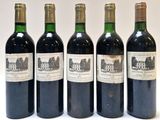 quatre bouteilles de vin sont alignées sur une surface blanche