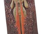 statue d'une femme aux cheveux longs, vêtue d'une robe orange, posée sur un socle en bois