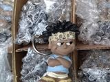 un petit porte-clés représentant un garçon avec un bandeau, dans une boîte en carton