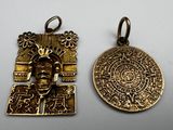 two gold pendants of a man with a medallion on it