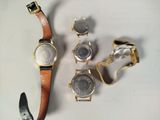 four watches and a watch chain on a table