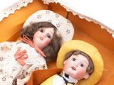 two dolls that are sitting in a box together