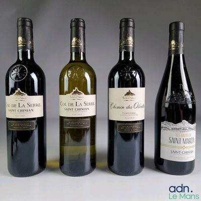 quatre bouteilles de vin sont alignées sur une table