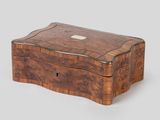an antique wooden box with a silver button on the lid