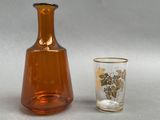 a glass and a bottle sitting next to each other on a table