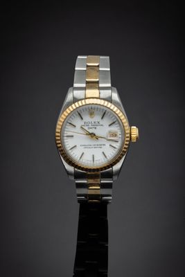 a close up of a watch on a black surface with a dark background